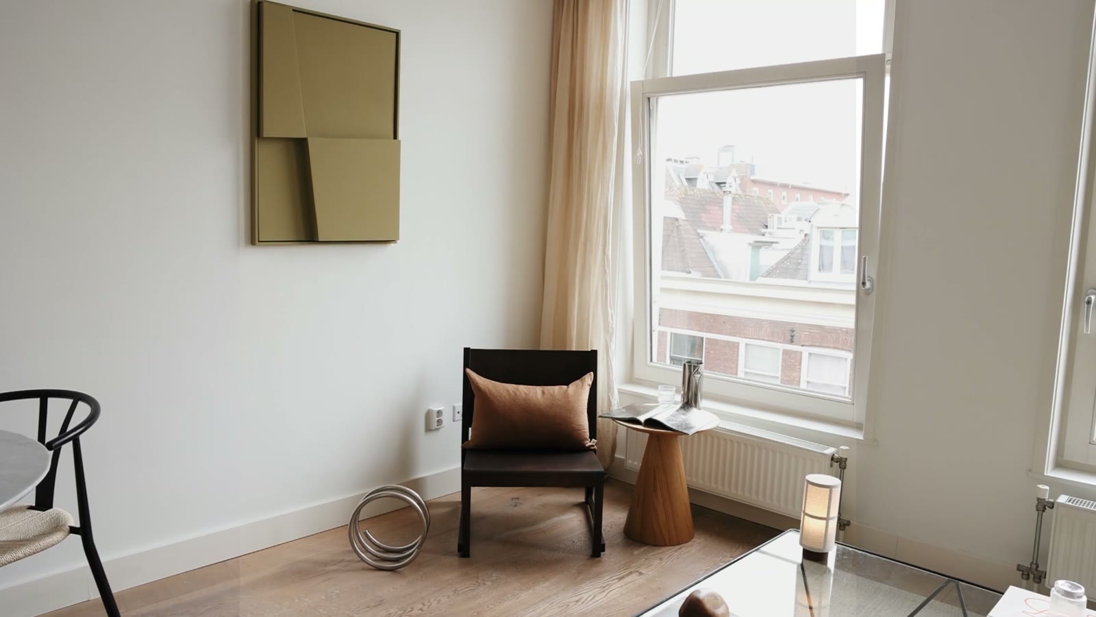 Gestyleerde eethoek met marmeren tafel, zwarte stoelen en papieren bollamp